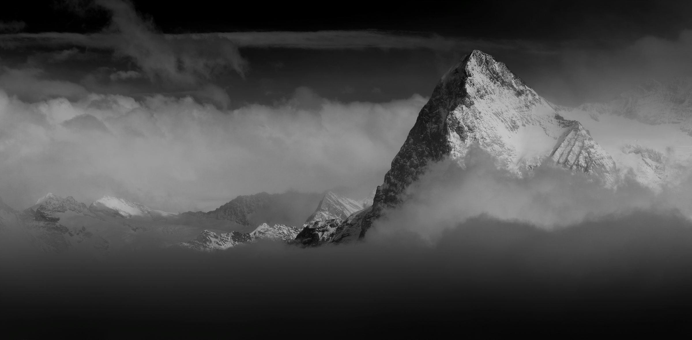 Dramatic mountain peak rising through clouds
